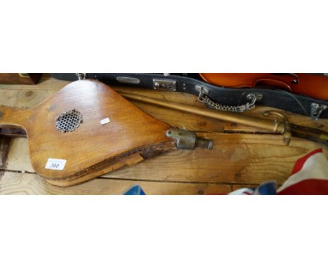 A world war I bayonet with a metal scabbard and a pair of oak and leather bellows.