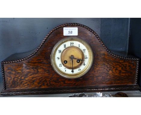 An early 20th Century oak cased Napoleon hat mantel clock, with a two train movement and white enamel bezel.