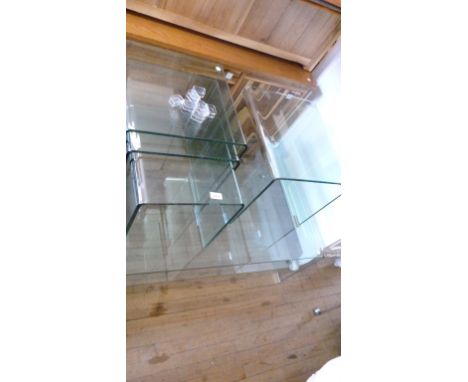 A contemporary nest of three glass tables conforming side table and coffee table with under shelf.