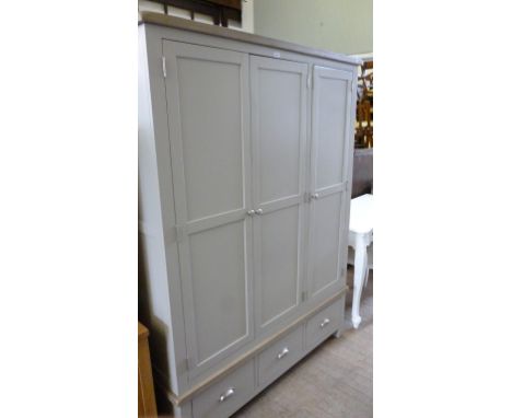 A contemporary painted and light oak triple wardrobe with three panelled doors above three drawers each with brushed metal ha