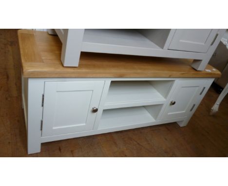 A light oak and painted TV stand with a slab top, above cupboard doors and open shelves.