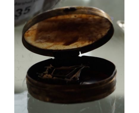 A gold mounted tortoiseshell patch box and a white metal pendant with a central coloured stone.