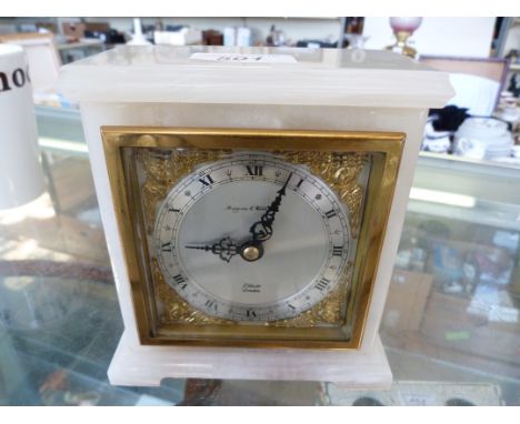 A Mappin & Webb white onyx mantel clock with a silvered dial signed Elliot London.