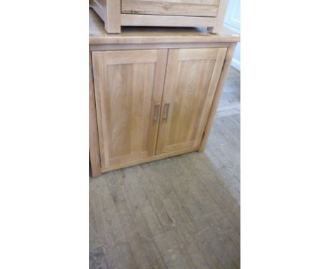 Good quality light oak cupboard fitted with two adjustable shelves enclosed by two doors.