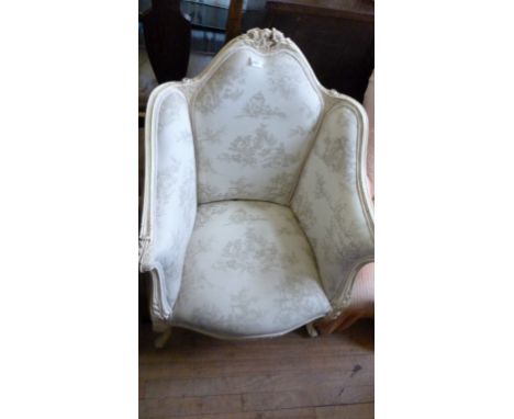 A painted and upholstered French style tub chair, the arch back with a flowerhead crest, raised on front cabriole legs