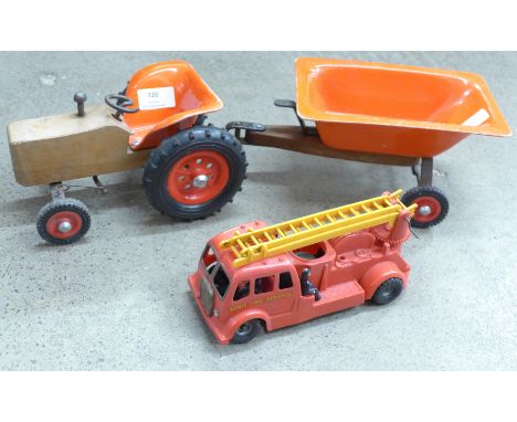 A vintage toy tractor with trailer and a Tri-ang Minic fire engine 