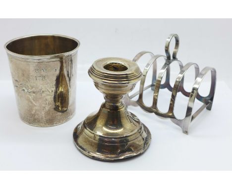 A silver toast rack, silver candle stick, a/f, and a continental measuring cup/beaker 