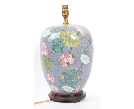 An early 20th century Chinese converted urn vase table lamp. The lamp of urn form, raised on a later wooden base, with brass 
