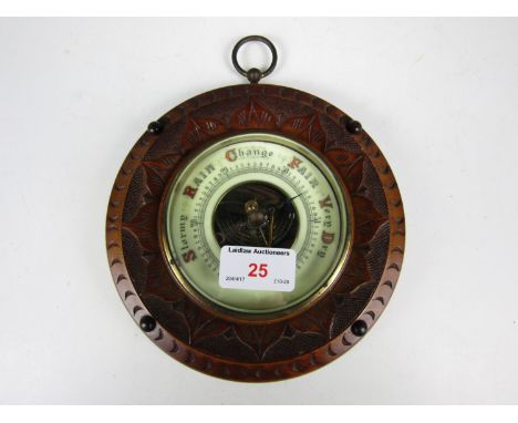 A late 19th Century carved mahogany circular barometer
