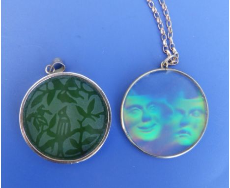 A 14k mounted circular carved jade disc pendant, 1.5" diameter and a yellow metal mounted hologram pendant on 9ct necklace ch