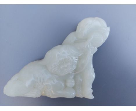 A Chinese jade group depicting an Immortal at play with a Shishi, 3.5" high.
