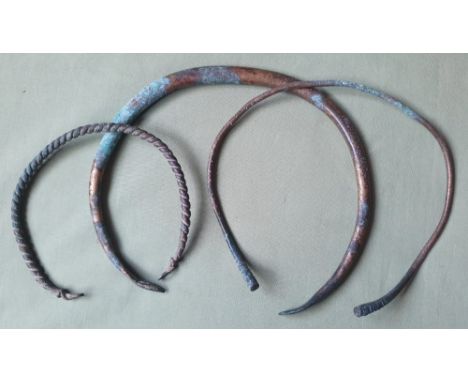 Three Iron Age copper alloy torcs, the largest of solid construction, 8.25".