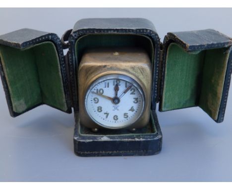 A small gilt metal continental carriage/travel clock in folding leather covered case, the clock 1.8" high.