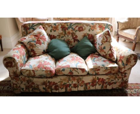 A large three seater Couch, covered in cream ground floral loose tapestry, together with a deep single Armchair with matching