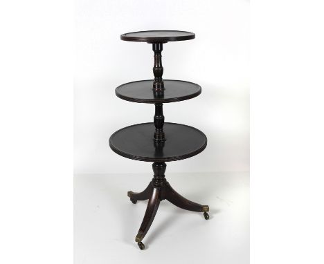 A George III circular mahogany Dumbwaiter, with three graduating shelves on a tripod base with brass castors, 120cms (47") hi