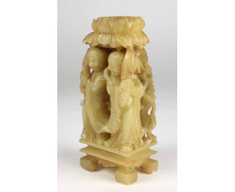 An early carved pale Celadon Jade Ornament, decorated with two figures in native attire, under a lotus flower, standing on a 