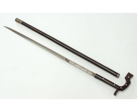 A wooden walking stick / scabbard with a nailed handle incorporating a sword. The stick L88cm, the blade L62cm.