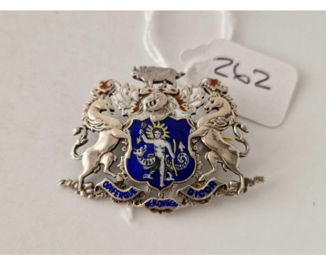 A silver and enamel brooch in the form of a family crest