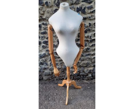 A mannequin/dressmaker's dummy with cloth body and articulated pine jointed arms on an adjustable  pine stand, 127cmH in phot