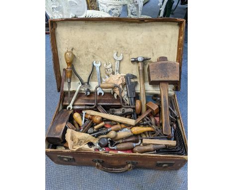 A selection of vintage tools to include wood working planes, spanners, mallet and other items contained in a leather suitcase