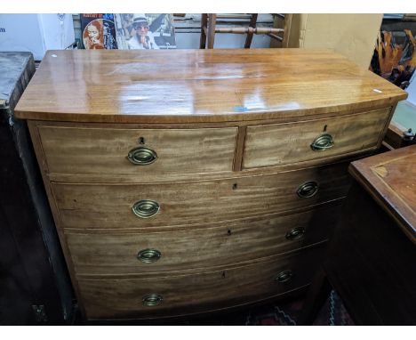 A Georgian mahogany bow fronted chest of two short and three long drawers, pine lined drawers, later brass handles on bracket