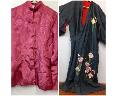 A 20th Century Japanese robe in black silk having hand-embroidered pink flowers and green tubular leaves with a red silk lini