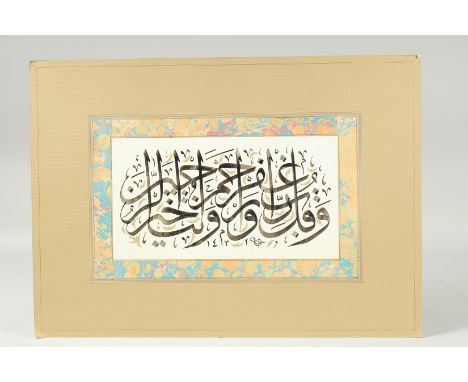 A 20TH CENTURY ISLAMIC PAINTED CALLIGRAPHIC PANEL, with fine gilt highlights and marbled border, 37.5cm x 52.5cm.