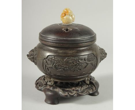 A CHINESE ARCHAIC STYLE BRONZE CENSER WITH CARVED JADE MOUNTED HARDWOOD COVER, on a fitted hardwood stand.