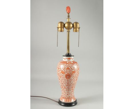 A CHINESE COPPER RED AND WHITE PORCELAIN VASE LAMP, painted with floral motif decoration, the lamp with carved foliate coral 