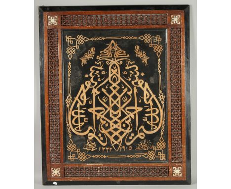 AN ISLAMIC CALLIGRAPHIC WOOD ON VELVET PANEL, glazed and inset within a mother of pearl inlaid frame, 86cm x 71cm.