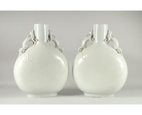A VERY LARGE PAIR BLANC-DE-CHINE TYPE MOON FLASK VASES, with moulded dragon handles, 47.5cm high.