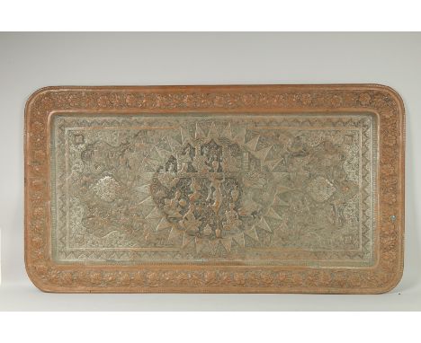 A VERY LARGE PERSIAN ISFAHAN EMBOSSED AND CHASED TINNED COPPER RECTANGULAR TRAY, with a central relief panel of musicians and
