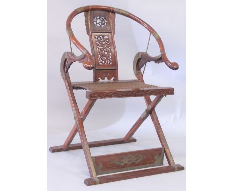 A CHINESE HARDWOOD HORSESHOE-BACK FOLDING CHAIR, with carved and pierced kylin panel and netted seat, the front legs united w