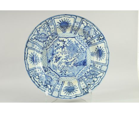 A CHINESE EXPORT BLUE AND WHITE PORCELAIN 'KRAAK' CHARGER, painted with a central panel of a bird and flora, 44cm diameter.