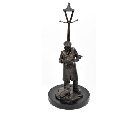 KNOX; a contemporary bronzed figure of a gentleman standing by a lamp post reading a newspaper with dog by his feet, height 4