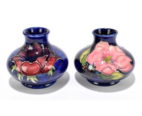 MOORCROFT; two squat vases decorated in the 'Anemone' and 'Magnolia' patterns on a blue ground, height 7.5cm (2).Additional I