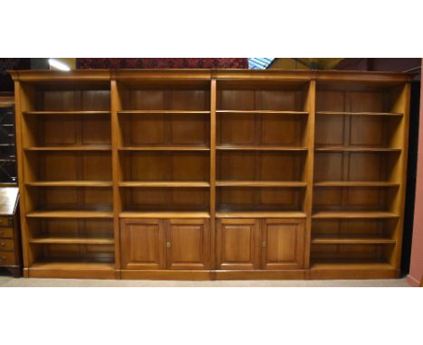 A very large modern cherry wood four sectioned open bookcase, the two central sections with twin cupboard door with adjustabl