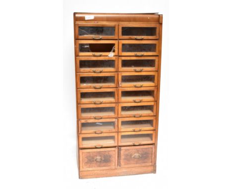 A mid-20th century walnut haberdashery cabinet, with two banks of glazed doors and two panel doors just above the plinth base