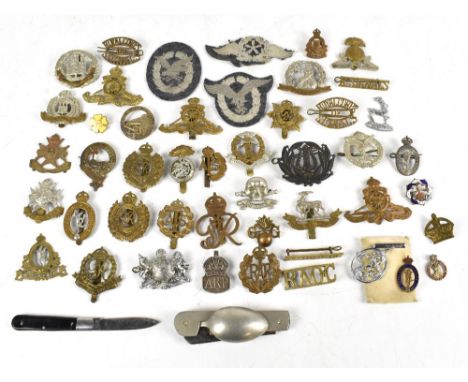 A collection of forty military cap badges and badges to include the Suffolk Regiment, The Lancashire Fusiliers, The Norfolk R