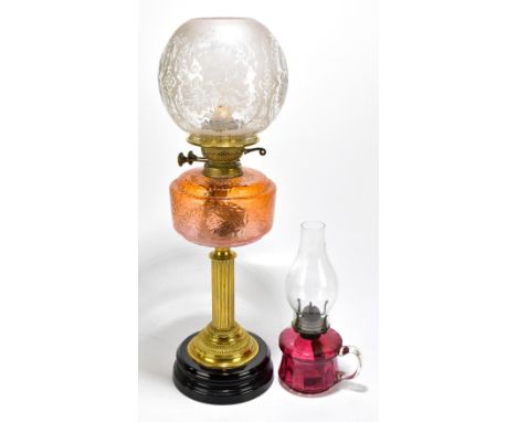 An early 20th century oil lamp with orange moulded glass reservoir and later frosted glass shade, height 60cm, together with 