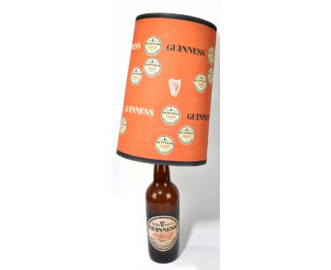 GUINNESS; a large glass advertising bottle lamp, with Guinness label and original shade, overall height 91cm.