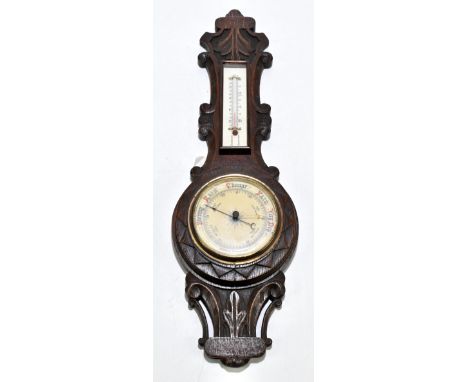 An early 20th century carved oak aneroid wheel barometer.
