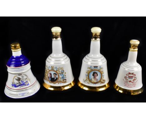 WHISKY; four Wade ceramic Bell's bell shaped ceramic decanters containing Scotch Whisky, varied examples including the marria