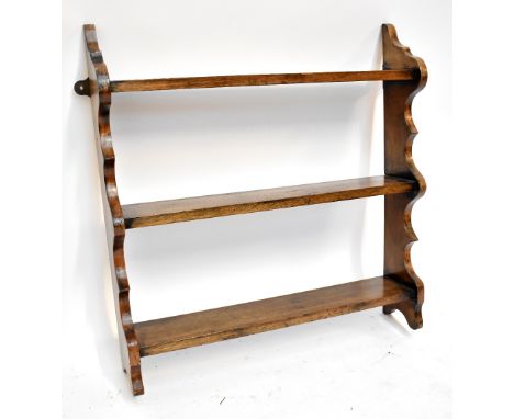 Two early 20th century oak spinning stools with carved backs and a mahogany three-tier hanging shelf.