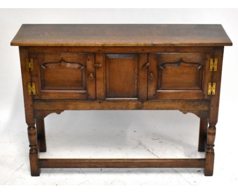 TITCHMARSH &amp; GOODWIN; a reproduction oak sideboard of small proportions with twin panel cupboard doors above ring turned 