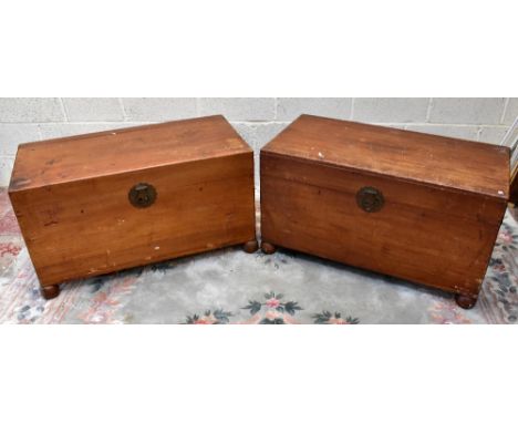 Two Chinese camphor wood chests, each with carved circular cabochon to the lid with a central initial K, raised on bun feet, 