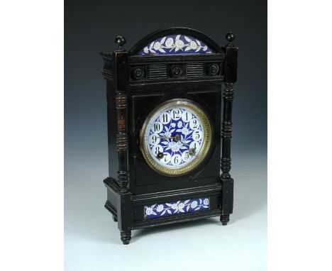 Attributed to Lewis Foreman Day, an Aesthetic movement ebonised striking mantle clock, circa 1880, the circular face painted 