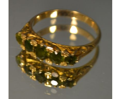 A 9ct gold ring set with five small faceted green stones (probably garnets)