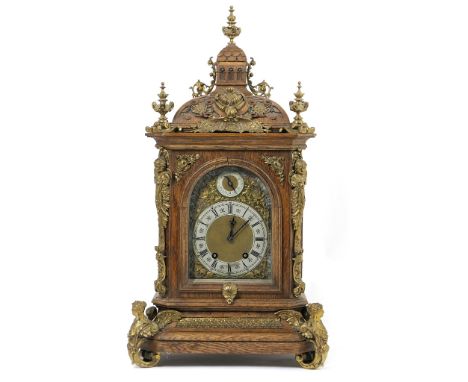 German oak bracket mantel clock, circa 1900, the domed case surmounted with brass urn finials and adornments over an arched b