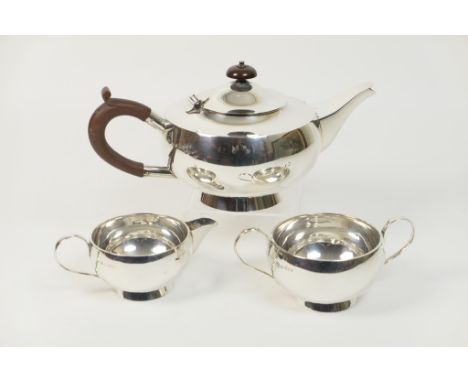 Hukin & Heath silver three piece tea service in the style of Dr. Christopher Dresser, London 1924, plain bun form, the teapot